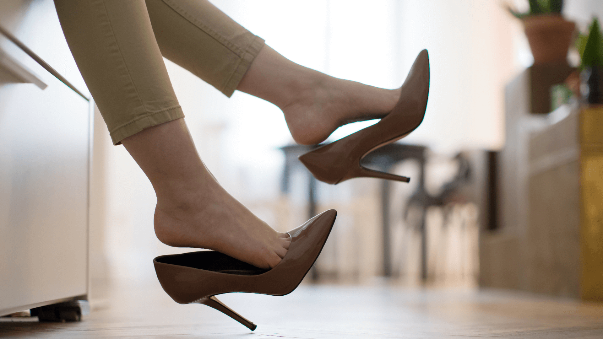 woman kicking brown heels off 