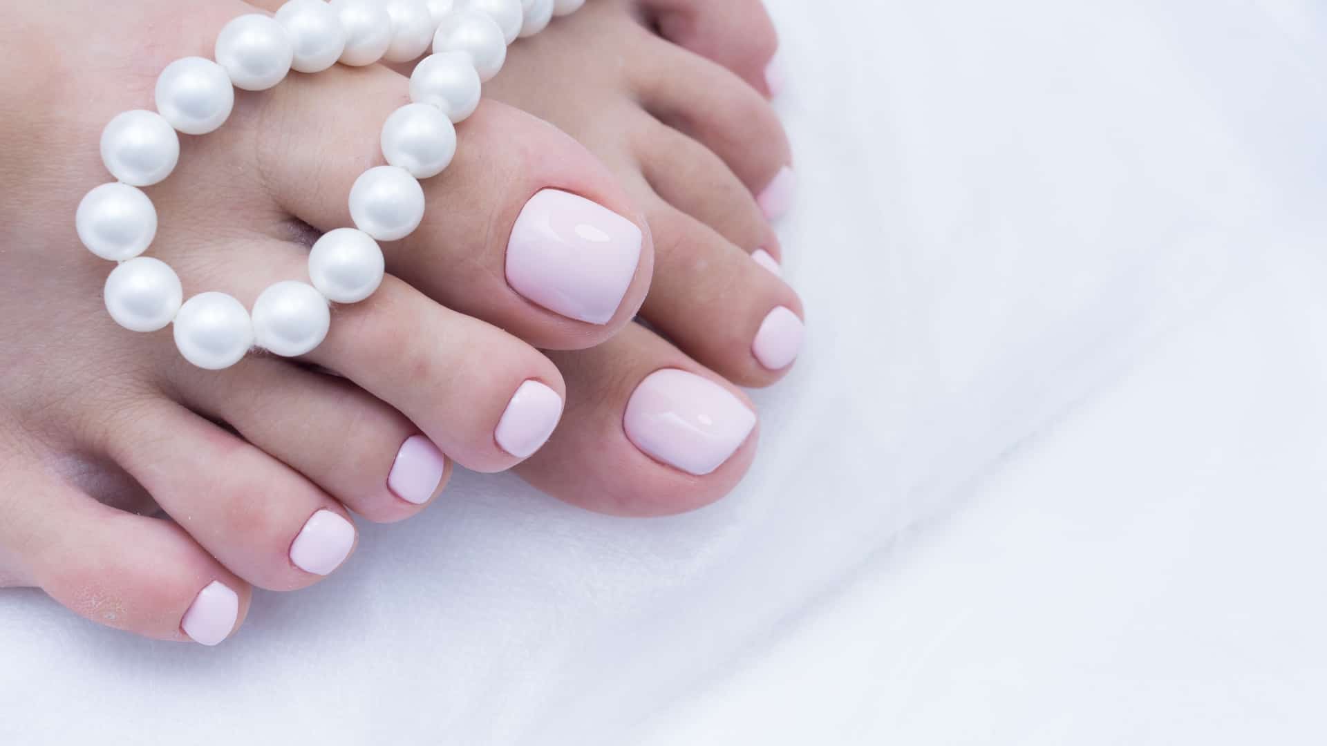Photo of close up of woman's manicured toenails painted pink
